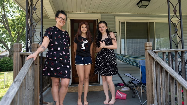Amanda Bailey, 35, from left, stands on her front porch...