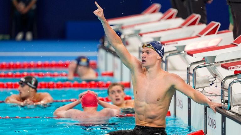 Leon Marchand, of France, celebrates after winning the men's 400-meter...