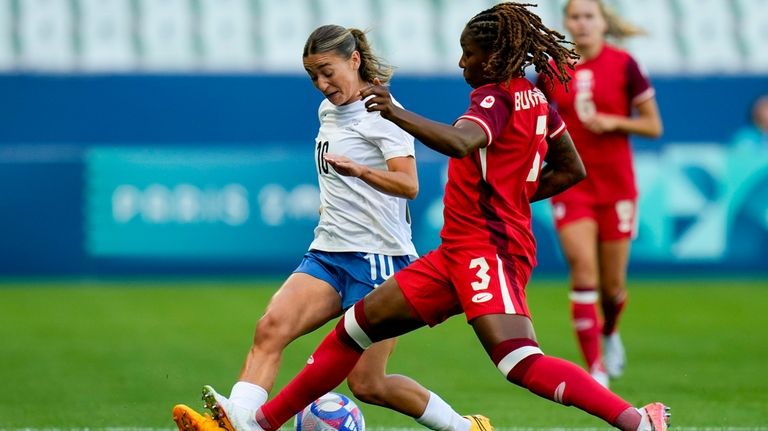 New Zealand's Indiah-Paige Riley, left, and Canada's Kadeisha Buchanan compete...