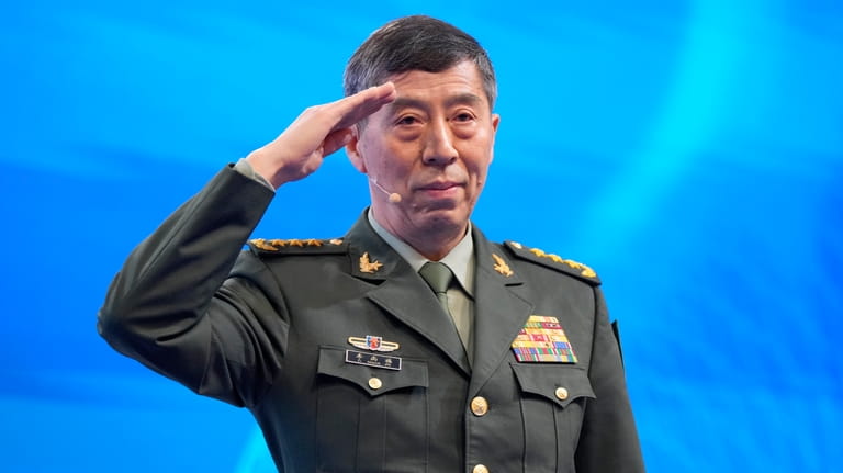 Chinese Defense Minister Li Shangfu salutes before delivering his speech...