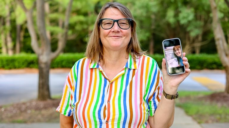 Susan Hogarth holds up her phone, July 24, 2024, in...