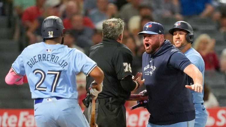 Home plate umpire Manny Gonzalez, center, argues with Toronto Blue...