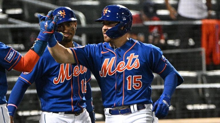 The Mets' Danny Mendick is greeted by Jeff McNeil and...