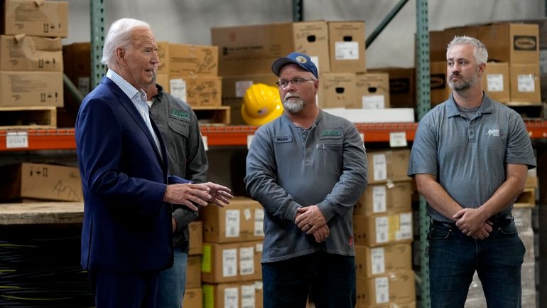 President Joe Biden, left, meets with workers from Dairyland Power...