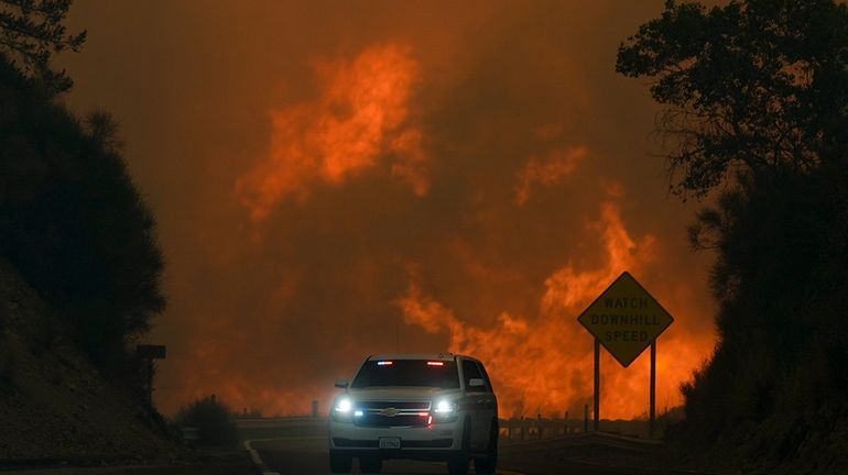 The Line Fire jumps Highway 330 as an emergency vehicle...