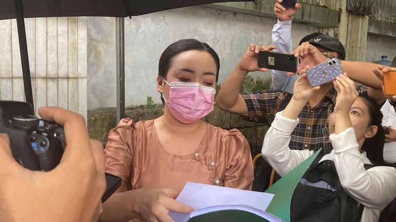 An unidentified legal official from Kamayut district court speaks outside...