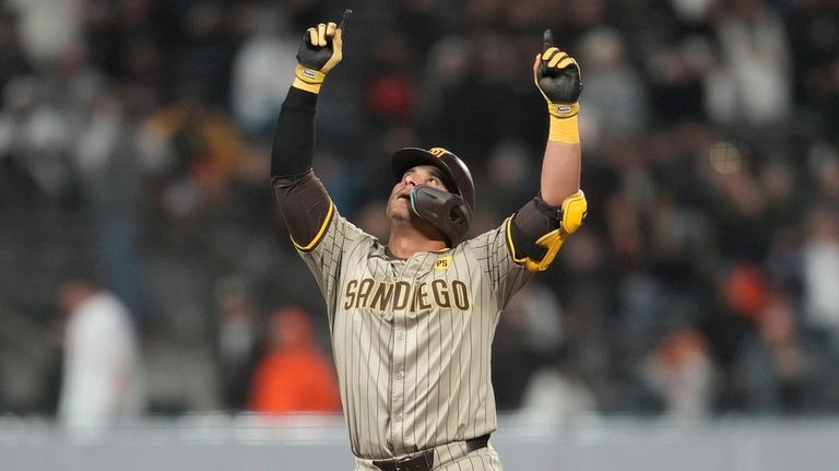 San Diego Padres' Donovan Solano gestures after hitting a double...