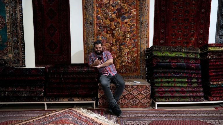 A salesman works on his cell phone at a carpet...