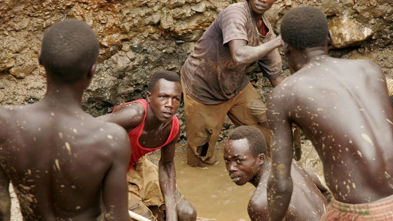 Ex-militia fighters work in a make-shift mine digging for gold...