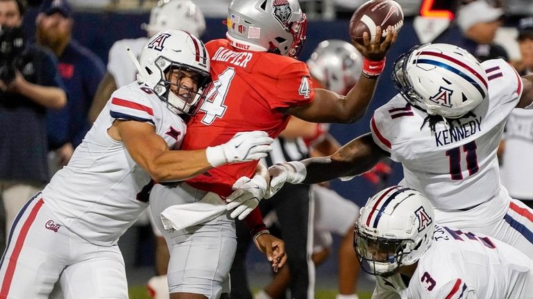 Arizona defensive players Taye Brown, left; Chase Kennedy, right; and...