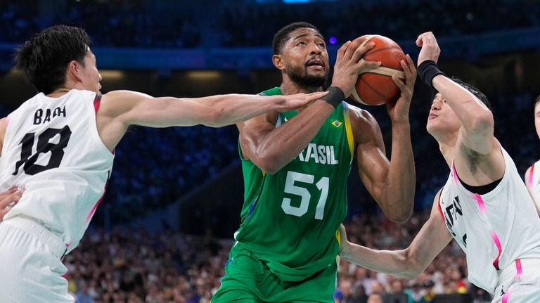 Bruno Caboclo, of Brazil shoots between Yudai Baba, left, and...