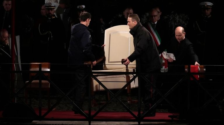 Vatican ushers carry away the Pope Francis' chair prior to...