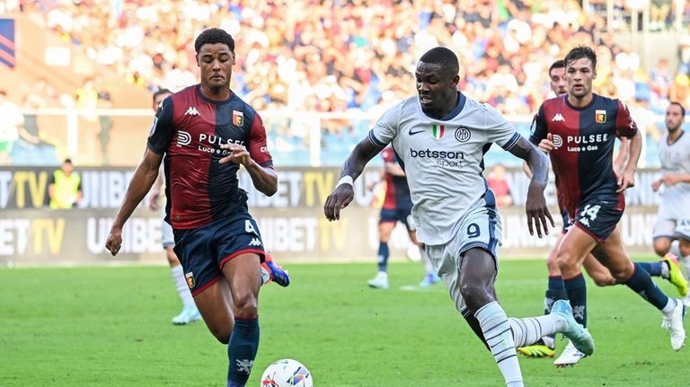 Genoa's Koni De Winter, left, fights for the ball with...