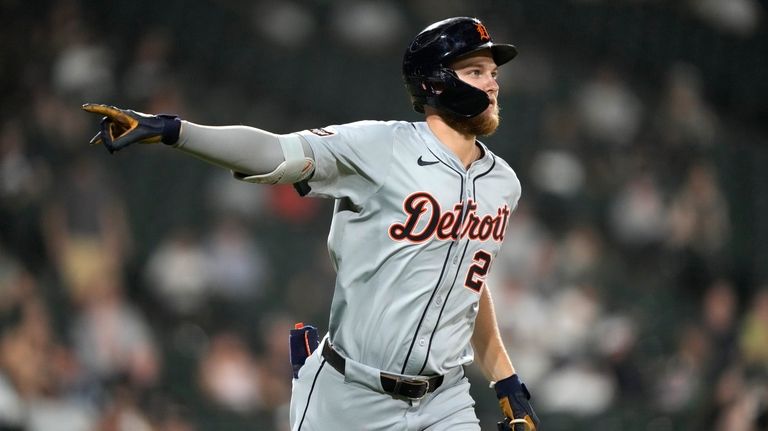 Detroit Tigers' Parker Meadows points to teammates in the dugout...