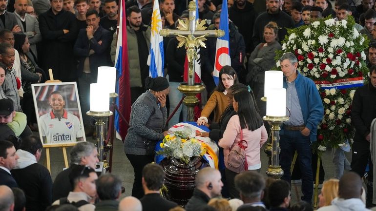 Family members of soccer player Juan Izquierdo stand by his...