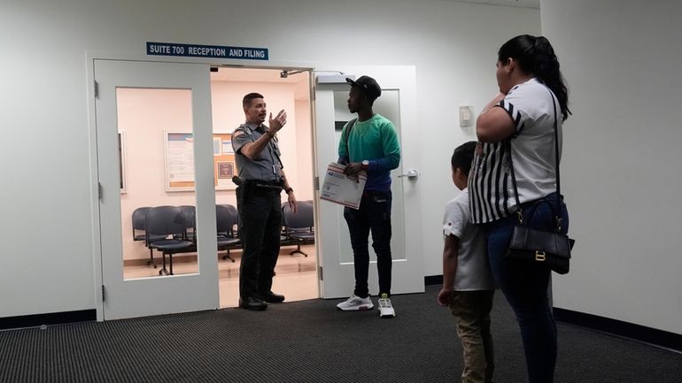 An officer directs people to a courtroom, Wednesday, Jan. 10,...