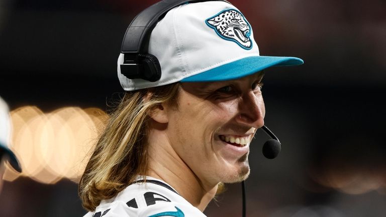 Jacksonville Jaguars quarterback Trevor Lawrence (16) stands on the sidelines...