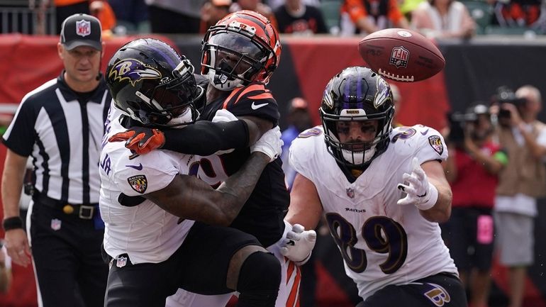 Cincinnati Bengals cornerback Cam Taylor-Britt, center, breaks up a pass...