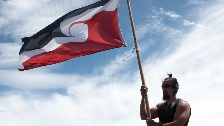 A Maori protester flies the Maori flag known as Tino...