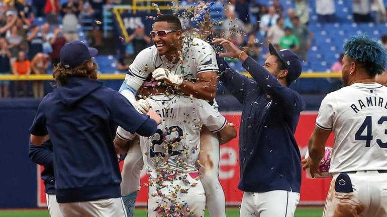 Tampa Bay Rays' Richie Palacios, center, is lifted by Jose...