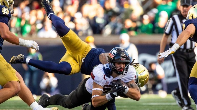 Northern Illinois tight end Grayson Barnes, center bottom, reaches for...