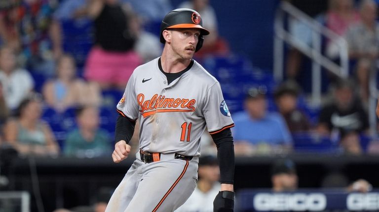 Baltimore Orioles' Jordan Westburg looks back as he scores on...