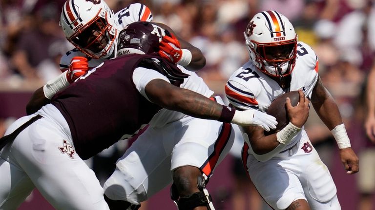 Auburn running back Jarquez Hunter (27) runs through the middle...