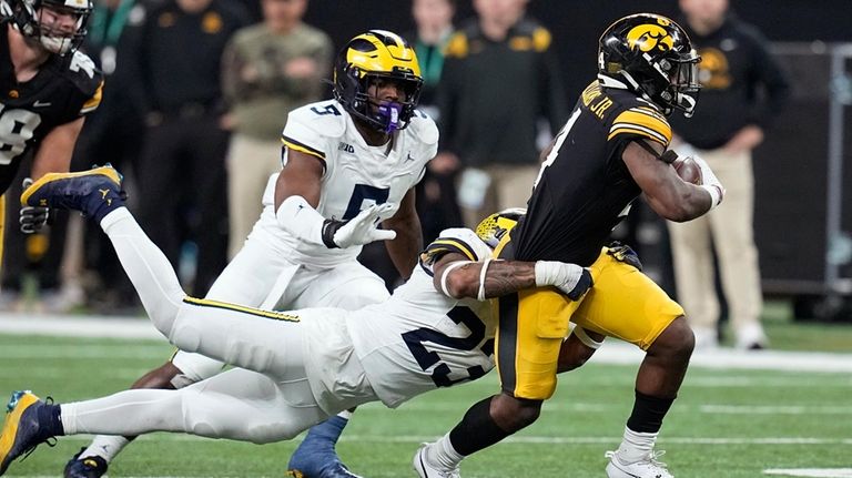 Iowa running back Leshon Williams (4) runs from Michigan linebacker...