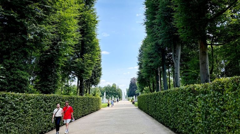 People walk in the park of the Sanssouci Palace in...