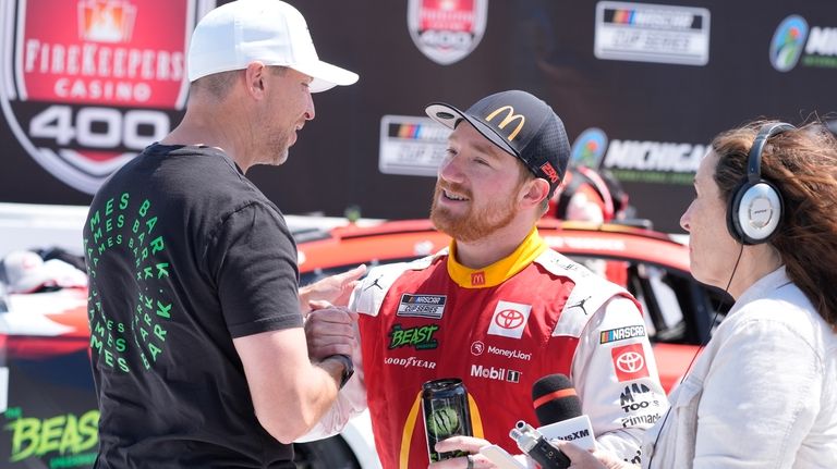 Tyler Reddick is greeted by Denny Hamlin after winning a...