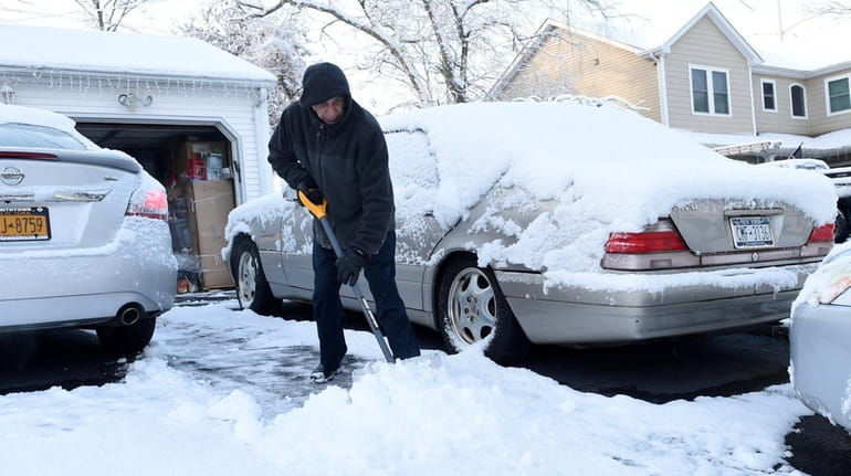 Joe Hama of Hauppauge shovels the snow from his driveway...