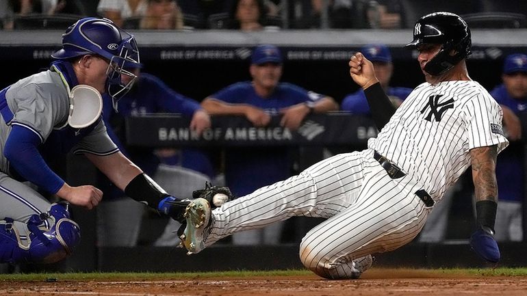 The Yankees' Gleyber Torres, right, is tagged out at home...