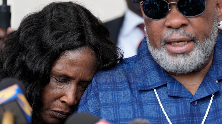 RowVaughn Wells rests on her husband's shoulder Rodney Wells, the...