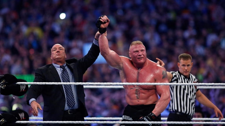Paul Heyman, left, celebrates with Brock Lesnar after his win...