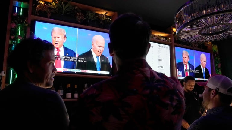 Patrons watch President Joe Biden debate Republican presidential candidate and...