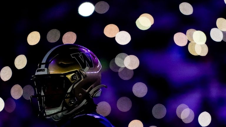 Washington cornerback Elijah Jackson is illuminated by flashing stadium lights...