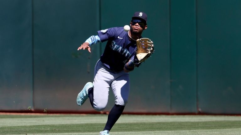 Seattle Mariners outfielder Julio Rodríguez catches a ball hit by...