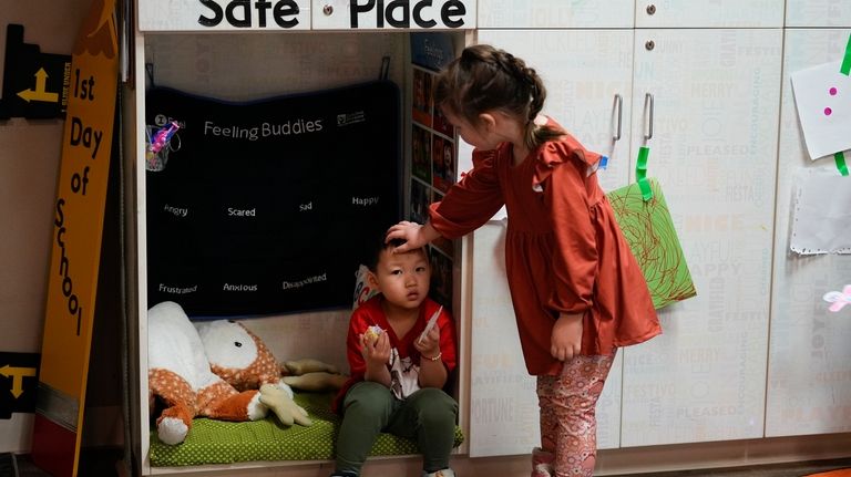 Willow Palmer, 5, at right, comforts classmate River Yang, 3,...