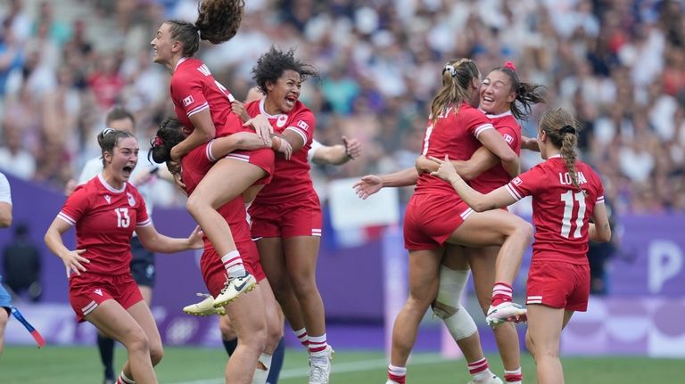 Members of the Canadian team celebrate after winning the women's...