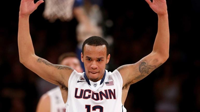 Shabazz Napier of the Connecticut Huskies rallies the fans in...