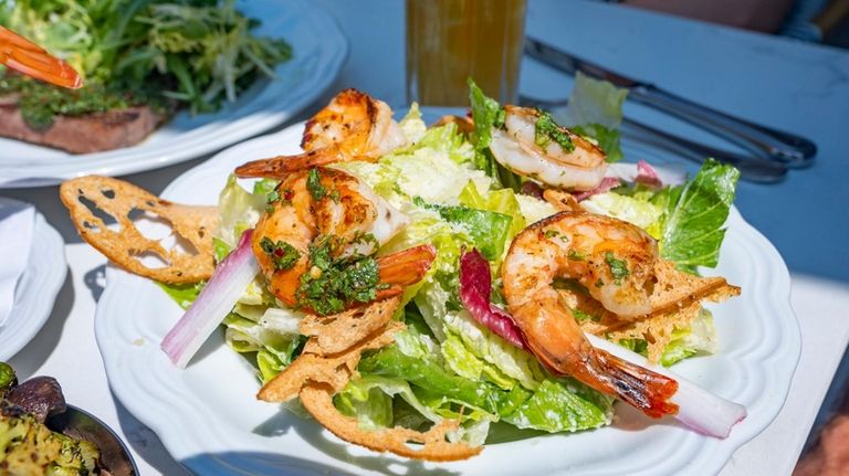 A Caesar salad and grilled shrimp on the terrace at...