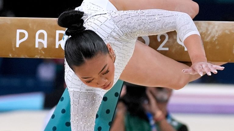 Suni Lee, of the United States, falls while competing during...