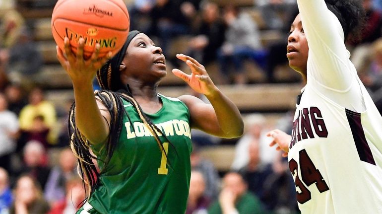 Longwood's Kanesha Strider scores against Ossining's Kailah Harris in a New York...