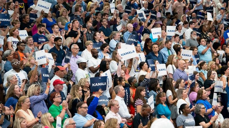 Supports hold up signs in support of Vice President Kamala...