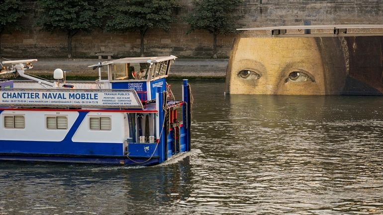 A ship sails past reproductions of artworks decorating the banks...