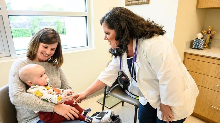 Jamey Hutchinson, right, a fertility care nurse at Catholic Health Service's Gianna...