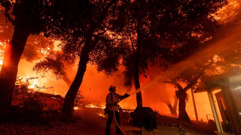 A firefighter battles the Airport Fire, Tuesday, Sept. 10, 2024,...