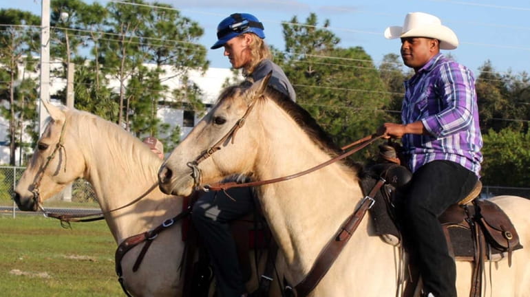 New York Mets' Yoenis Cespedes, right, and Noah Syndergaard ride...