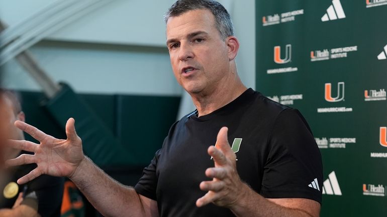 Miami head coach Mario Cristobal speaks with the media following...