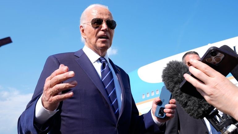 President Joe Biden speaks to the media as he arrives...